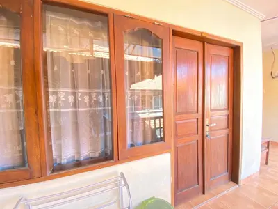 a room with wooden doors and windows at ABI Hotel2 - 1 minute to the Beach and 1 second to the Mall in Ngurah Rai International Airport