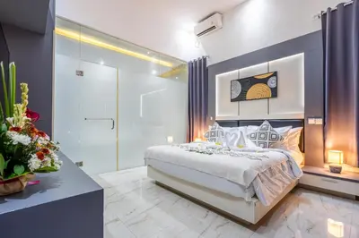 a bedroom with a king sized bed and a walk in shower at Villa Naga by JB Villas in Seminyak