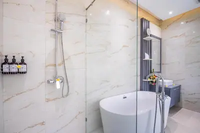 a bathroom with a shower with a toilet and a sink at Villa Naga by JB Villas in Seminyak