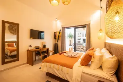 a bedroom with a bed and a desk and a mirror at Villa ADDI 4bedrooms Oberoi in Seminyak