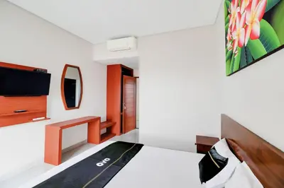 a bedroom with a bed and a tv on the wall at Collection O Bali Sanur near Bali Mandara Hospital in Sanur