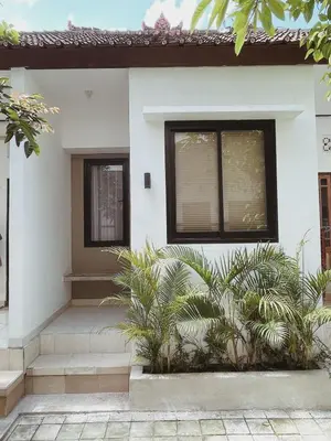 a house with two windows and plants in front of it at Sukanadi's Homestay in Legian