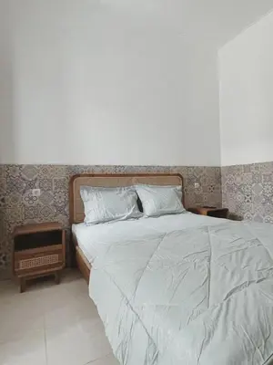 a bedroom with a large bed with a white blanket at Sukanadi's Homestay in Legian