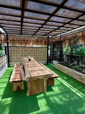 a wooden table and bench in a pavilion at Villa Vela in the heart of Seminyak in Seminyak
