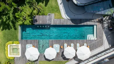 an overhead view of a swimming pool with umbrellas at Dreamtime House Bali in Canggu