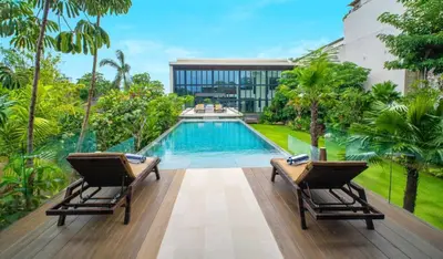 a swimming pool with two chairs on a wooden deck at Lillypad 5Bed Villa in Seminyak