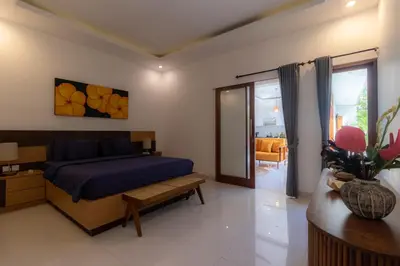 a bedroom with a bed and a table and a couch at Villa Suka Damai Peaceful 2 Bedroom Getaway in Seminyak