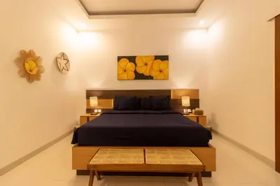 a bedroom with a bed and a clock on the wall at Villa Suka Damai Peaceful 2 Bedroom Getaway in Seminyak
