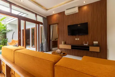 a living room with orange furniture and a flat screen tv at Villa Suka Damai Peaceful 2 Bedroom Getaway in Seminyak