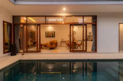 a house with a swimming pool and a living room at Villa Suka Damai Peaceful 2 Bedroom Getaway in Seminyak