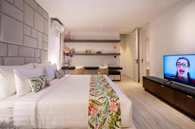 a bedroom with a large bed and a flat screen tv at House of Light 5bed villa in Canggu