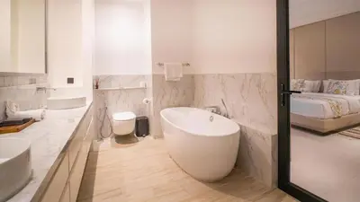 a bathroom with two sinks and a tub and a bed at House of Light 5bed villa in Canggu