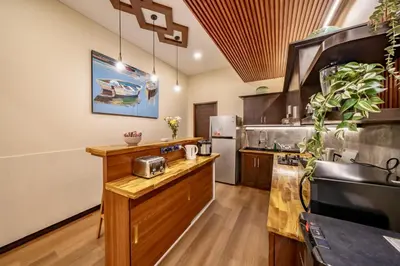 a kitchen with a wooden counter and a refrigerator at Seminyak Happy Villa in Legian