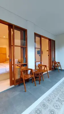 a room with tables and chairs and a bed at AA Inn Kuta Beach in Ngurah Rai International Airport