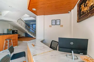 a living room with a table and chairs and a staircase at AA Inn Kuta Beach in Ngurah Rai International Airport
