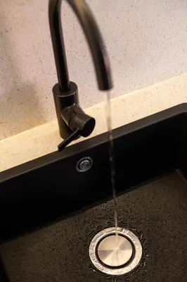 a sink with a faucet with water coming out of a drain at Harmoni Lane Studios in Seminyak