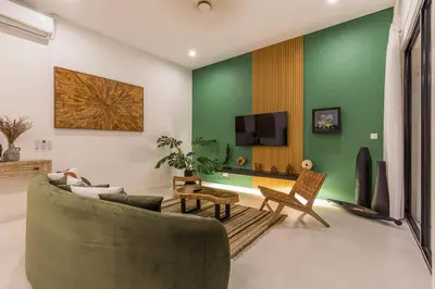 a living room with a couch and a tv at VILLA BIBA cosy and stylish in Canggu