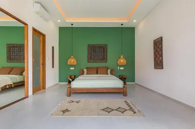 a bedroom with a bed and a green wall at VILLA BIBA cosy and stylish in Canggu