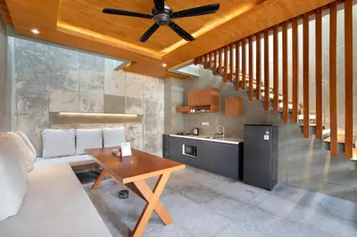 a living room with a ceiling fan and a table at Aqilah Villa Bali in Legian