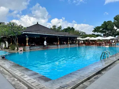 a large blue swimming pool next to a restaurant at Apartment at Jayakarta Residence Beach Front Access in Seminyak