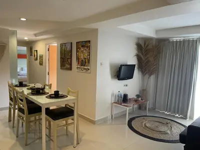 a kitchen and living room with a table and chairs at Apartment Keluarga di Kuta Bali in Kuta
