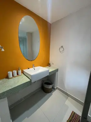 a bathroom with a sink and a mirror at Apartment Keluarga di Kuta Bali in Kuta
