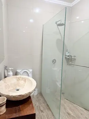 a bathroom with a sink and a glass shower at Villa Mimi Mesari Kuta Bali in Kuta