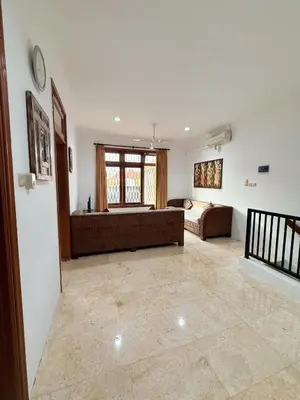 a living room with a couch and a bed in it at Villa Mimi Mesari Kuta Bali in Kuta