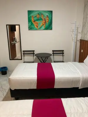 a bedroom with a large bed with a pink and white blanket at Hotel Sanrina Kuta Bali in Kuta