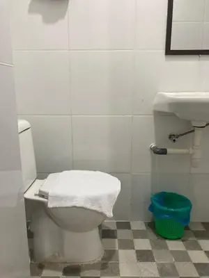 a bathroom with a white toilet and a sink at Hotel Sanrina Kuta Bali in Kuta