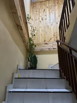a staircase with a potted plant and a wooden wall at Sari Buana Bed & Breakfast in Kuta