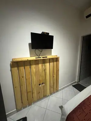 a television on top of a wooden cabinet in a room at Sari Buana Bed & Breakfast in Kuta