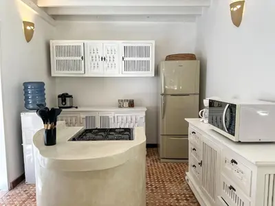 a kitchen with a stove and a microwave at Villa Santai by Optimum Bali Villas in Canggu