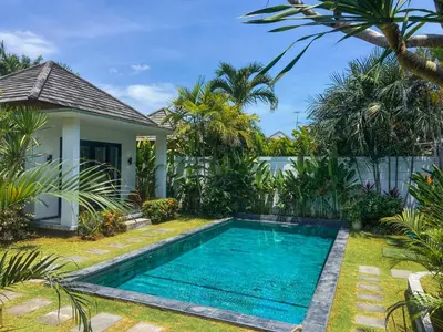 a swimming pool in front of a villa at Splendid 3 BR villa with large pool and garden in Canggu