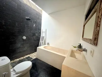 a bathroom with a tub and a toilet and a sink at Villa Omarama Seminyak Beach in Seminyak