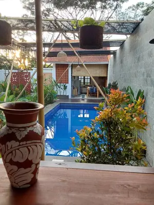 a vase sitting on a table next to a swimming pool at Navalia Rumah Kayu in Kerobokan