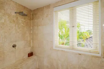 a bathroom with a shower and a window at Boholuma Villas by Pertama Management in Seminyak