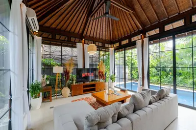 a living room with a large couch and a table at Boholuma Villas by Pertama Management in Seminyak