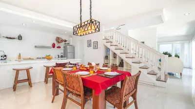 a kitchen and dining room with a red table and chairs at Villa Alun by Villa Finder in Canggu