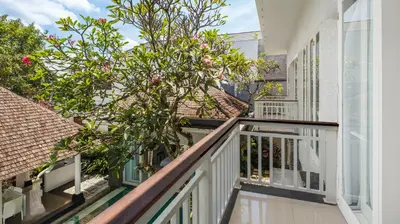 a balcony of a house with a tree at Villa Alun by Villa Finder in Canggu