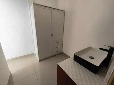 a white room with a cabinet and a table at Villa Videl in Seminyak