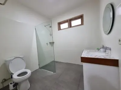 a bathroom with a toilet and a shower and a sink at Villa Videl in Seminyak