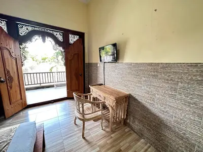 a room with a table and a chair and a window at Osa Guest House 5 in Seminyak