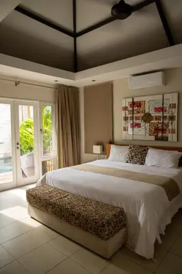 a bedroom with a large bed and a large window at Villa Kazari Zen in Seminyak