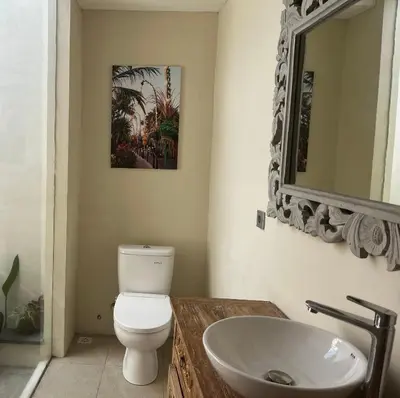 a bathroom with a white toilet and a sink at Villa Kazari Zen in Seminyak