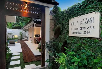 a sign on the side of a building with plants at Villa Kazari Zen in Seminyak
