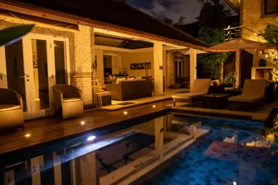 a house with a swimming pool at night at Villa Kazari Zen in Seminyak
