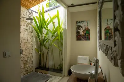 a bathroom with a sink and a glass shower at Villa Kazari Zen in Seminyak