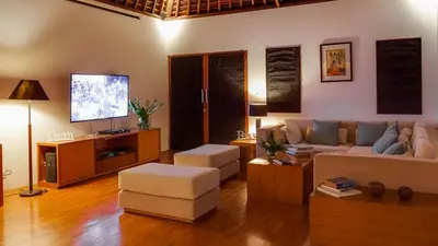 a living room with a couch and a flat screen tv at Villa The Beji in Canggu