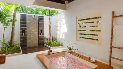 a bathroom with a large bath tub with a window at Villa The Beji in Canggu